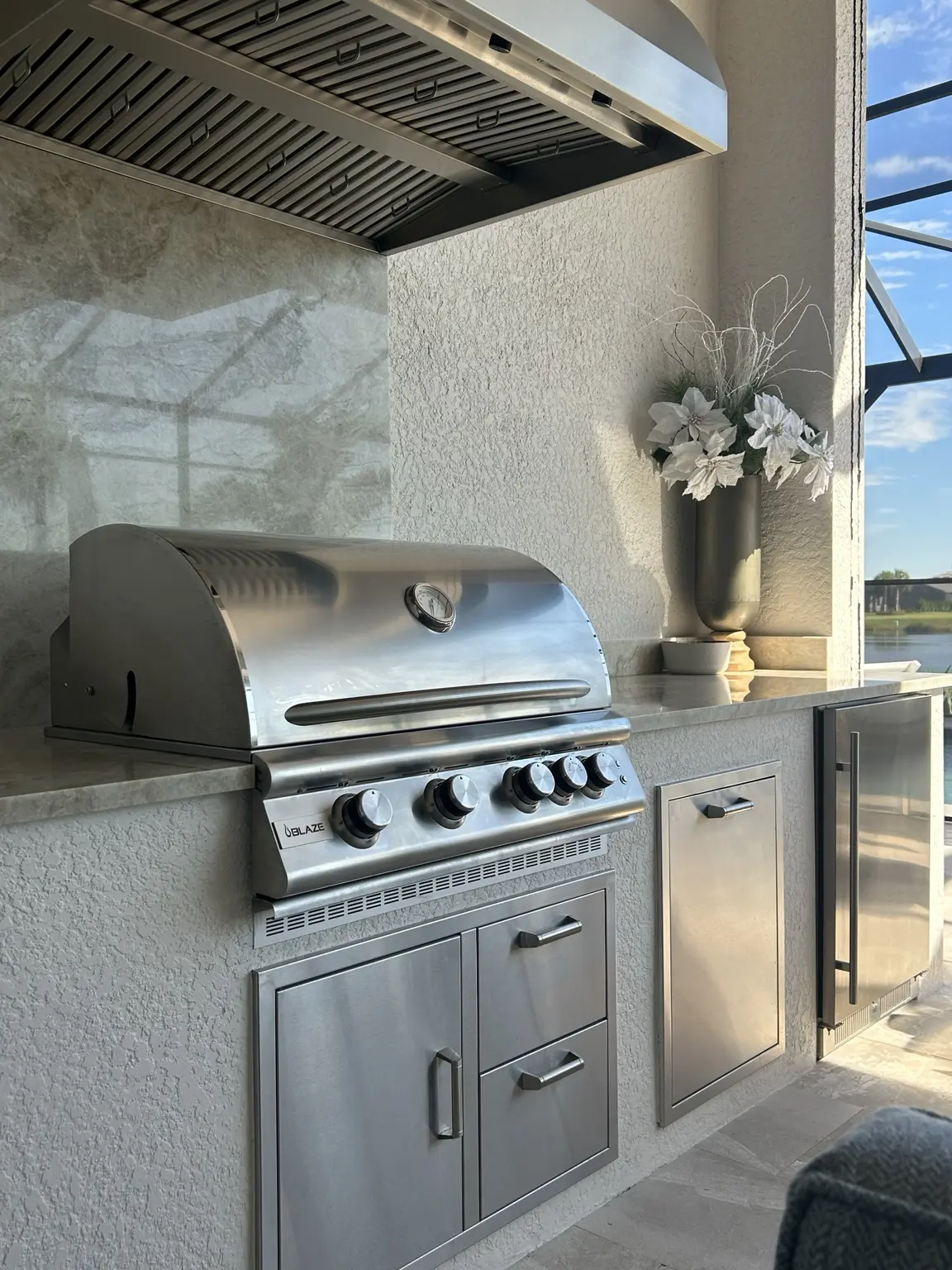 Custom site-built stucco outdoor kitchen with Blaze grill, access doors and refrigerator